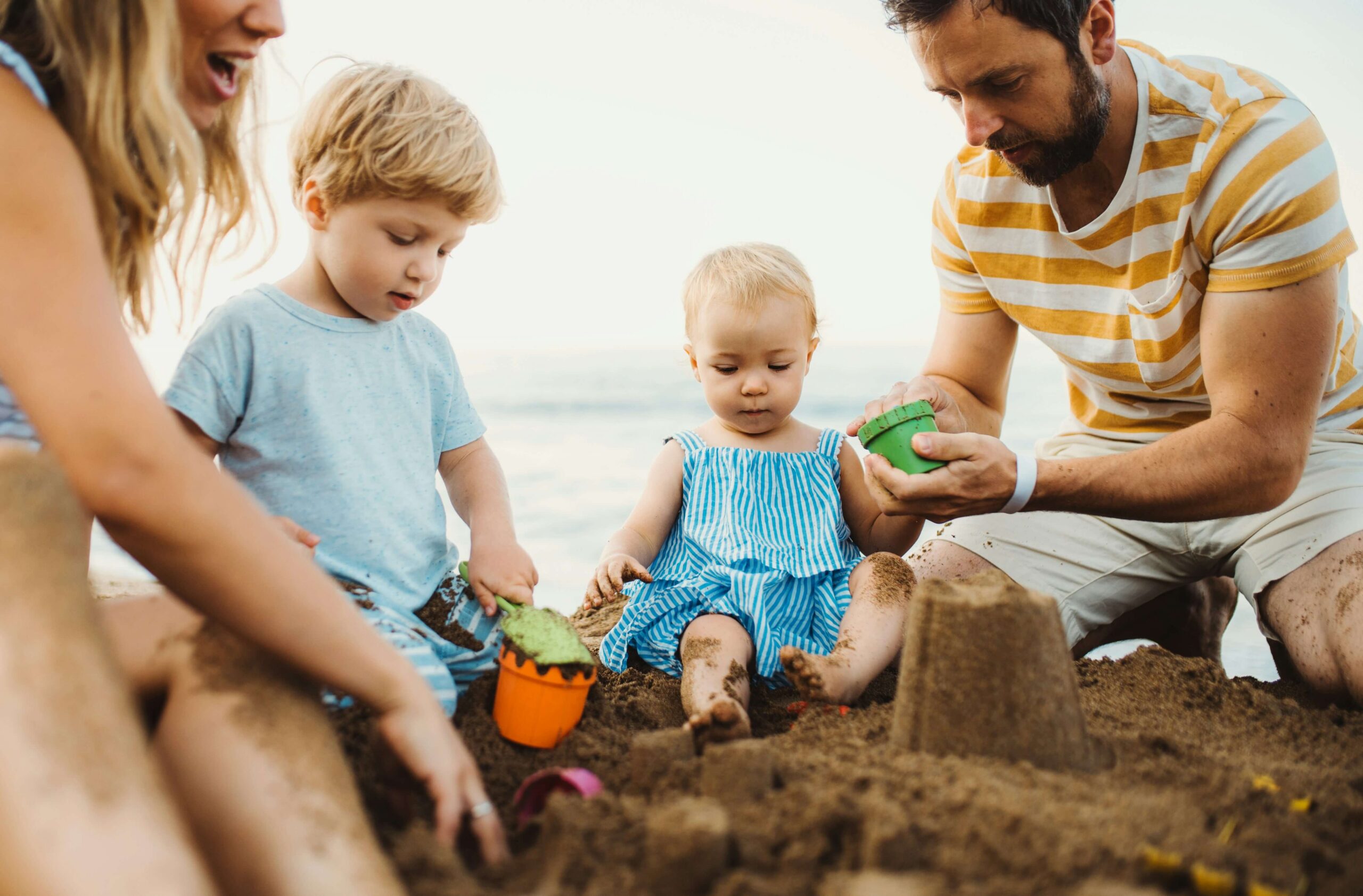 Family of 4 playing in the sand